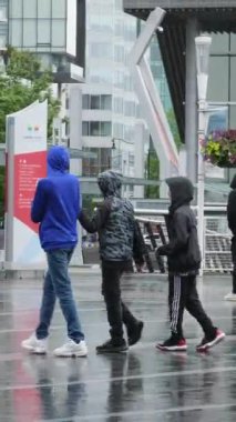 Kanada 'nın göbeğinde yağmurlu bir bahar var. Büyük anne ve büyük baba, şemsiyeli kadın ve erkekler, valizli insanlar, şehirde gezen yerel turistler. Merkezde yağmur var. Vancouver Kanada İngiliz Kolombiyası 05.04.2024