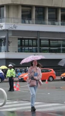 Kanada 'nın göbeğinde yağmurlu bir bahar var. Büyük anne ve büyük baba, şemsiyeli kadın ve erkekler, valizli insanlar, şehirde gezen yerel turistler. Merkezde yağmur var. Vancouver Kanada İngiliz Kolombiyası 05.04.2024