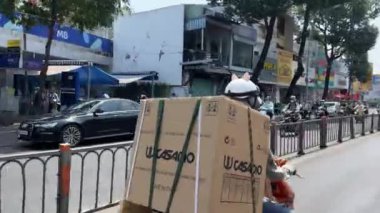 Şehir merkezindeki büyük bir şehirde trafik vardı. İnsanlar motosiklet kullanıyordu. Yol kuralları yoktu, maskeler takıyorlardı.. 