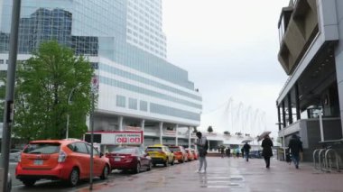 Kanada 'nın göbeğinde yağmurlu bir bahar var. Büyük anne ve büyük baba, şemsiyeli kadın ve erkekler, valizli insanlar, şehirde gezen yerel turistler. Merkezde yağmur var. Vancouver Kanada İngiliz Kolombiyası 05.04.2024