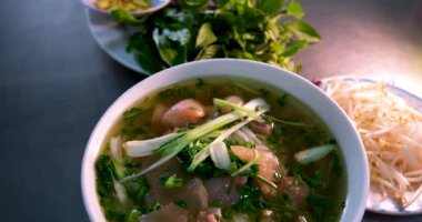 Pho Vietnamlı Çorbası, Asya sokak kafesi. Vietnam eriştesi çorbası, foto çorbası. Turistler sokak yemeklerini sever. Yüksek kalite 4k görüntü