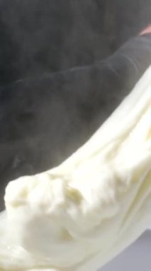 Caciocavallo kabak peyniriyle ev yapımı peynir fabrikasında adım adım kachakovala peyniri nasıl hazırlanır? Siyah lateks eldivenli kadın elleri İtalya 'da lezzetli bir ürün hazırlar. 4k