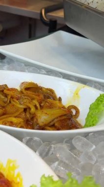 Erkek bir aşçının iki eli de fast food restoranında ızgara sıcak tavuk ızgara için baharatlı baharatla marine edilmiş çiğ tavuk bacağı ve kırmızı biber yoğurur. Yemek servisi ve paket servis. Yüksek kalite