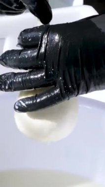 Caciocavallo kabak peyniriyle ev yapımı peynir fabrikasında adım adım kachakovala peyniri nasıl hazırlanır? Siyah lateks eldivenli kadın elleri İtalya 'da lezzetli bir ürün hazırlar. 4k