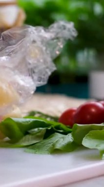 Caciocavallo peynirinin yapışkan ellerini pencere kenarındaki pencere kenarındaki domateslerin üzerindeki iç pencere fidelerine yapıştırır. Lezzetli süt ürünleri. Yüksek kalite 4k görüntü