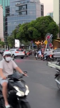 Yoğun yolda motosiklet trafiği. İnsanlar ve arabalar oradan geçerken. HO CHI MINH ŞEHRİ, VİETNAM 05.10.2024