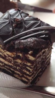 Lezzetli bir parça çikolatalı pasta yiyorum. Çikolatalı pasta yiyorum. Çatalla lezzetli çikolatalı pastadan bir ısırık almak. Yüksek kalite 4k görüntü