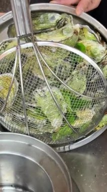 Haşlanmış istiridyeler açık büfe masası için suyu kabuklu istiridye dolu büyük bir tavada süzer. Yüksek kalite 4k görüntü