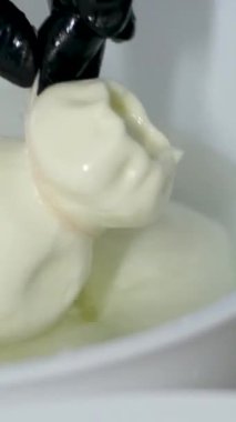  Adam İtalyan mozzarella ve caciocavallo hazırlamak için ahşap bir kabın içinde peynir parçaları hazırlıyor. Yüksek kalite 4k görüntü
