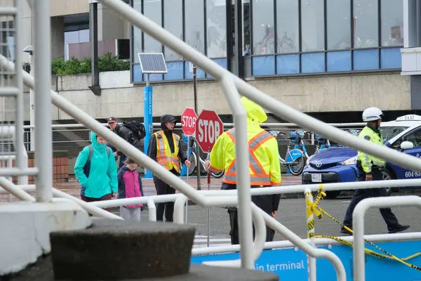 Kanada 'nın göbeğinde yağmurlu bir bahar var. Büyük anne ve büyük baba, şemsiyeli kadın ve erkekler, valizli insanlar, şehirde gezen yerel turistler. Merkezde yağmur var. Vancouver Kanada İngiliz Kolombiyası 05.04.2024