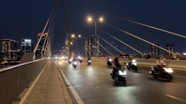 Gece yarısı Ho Chi Minh şehir merkezi yeni alan gökdelenleri büyük nehir ve köprü arabaları motosikletler büyük şehir turizminde gerçek hayat trafiği. Yüksek kalite 4k görüntü