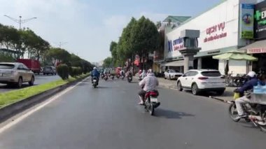 Ho Chi Minh Şehri motosikletleri maskeli ve miğferli insanlar taşıma araçlarıyla şehirde hızlı bir şekilde dolaşıyorlar. Vietnam Ho Chi Minh Şehri 05.28.2024