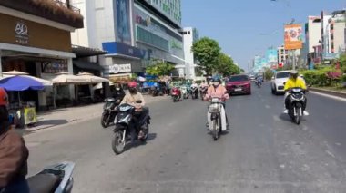 Ho Chi Minh Şehri motosikletleri maskeli ve miğferli insanlar taşıma araçlarıyla şehirde hızlı bir şekilde dolaşıyorlar. Yüksek kalite 4k görüntü