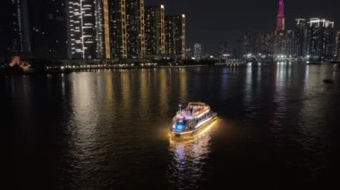 Gece yarısı Ho Chi Minh şehir merkezi yeni alan gökdelenleri büyük nehir ve köprü arabaları motosikletler büyük şehir turizminde gerçek hayat trafiği. Yüksek kalite 4k görüntü