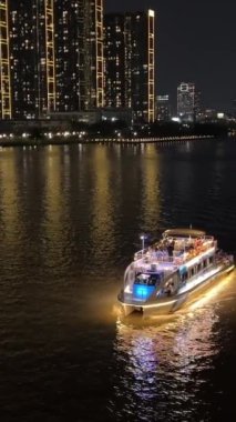 Gece yarısı Ho Chi Minh şehir merkezi yeni alan gökdelenleri büyük nehir ve köprü arabaları motosikletler büyük şehir turizminde gerçek hayat trafiği. Yüksek kalite 4k görüntü