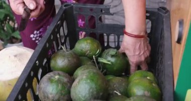 Vietnam 'da yeşil portakallardan meyve suyu sıkan mükemmel bir kadın sokakta sağlıksız meyve sıkacağı. Yüksek kaliteli FullHD görüntüler