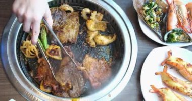 Vietnam, restorandaki bir masada kızartma tavasında et kızartıyor. Akşam yemeği için bir kafede baharatlı et hazırlanıyor.