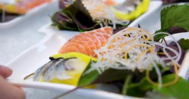 Kırmızı balık fesleğenli lahana turşusu ve açık büfe porsiyonunda kadın eli servis eden ringa balığı tabağı alıyor. Yüksek kaliteli FullHD görüntüler