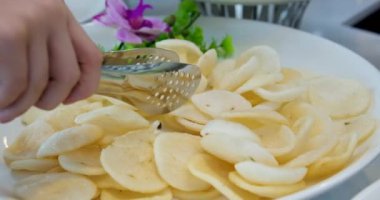 Kerupuk, pirinç unundan yapılan bir çeşit aperatif, beyaz arka planda izole edilmiş küçük bir tabakta servis edilir. Yüksek kalite