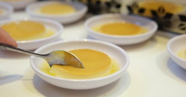 Masada güneş ışığıyla servis edilen ramekin içinde karamel kabuklu leziz creme brulee tatlısının en üst görüntüsü. Yüksek kalite fotoğraf