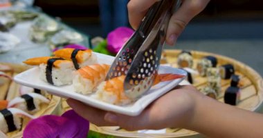 Suşi çubukları sarıp Japon usulü suşi yiyor. Yüksek kaliteli FullHD görüntüler