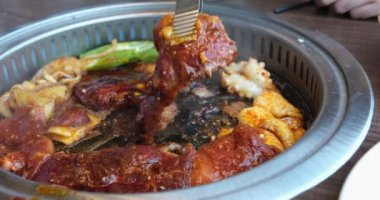 Vietnam, restorandaki bir masada kızartma tavasında et kızartıyor. Akşam yemeği için bir kafede baharatlı et hazırlanıyor.