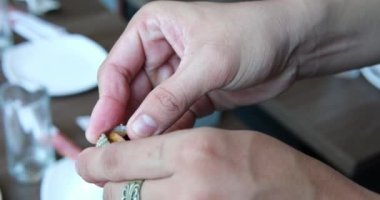 Erkek eli kabuğu açar, midyeyi çıkarır, kabuğu nasıl doğru şekilde açacağını gösterir. Yüksek kaliteli FullHD görüntüler