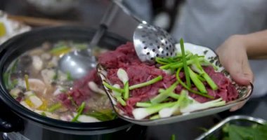 Yeşil soğanlar kaynar suyla sıcak çorbaya et ekler. Asya Vietnam mutfağı çorbası fa