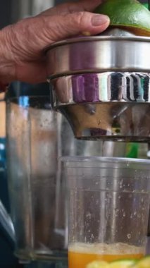 Vietnam 'da yeşil portakallardan meyve suyu sıkan mükemmel bir kadın sokakta sağlıksız meyve sıkacağı. Yüksek kaliteli FullHD görüntüler