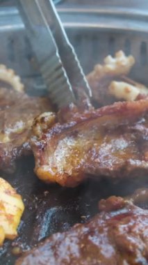 Vietnam, restorandaki bir masada kızartma tavasında et kızartıyor. Akşam yemeği için bir kafede baharatlı et hazırlanıyor.