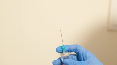 Mavi eldiven, laboratuarda durup test tüpünü tutabilmek için vakum tüpü yerleştirdi. Mikro küp. Vakum kan toplama tüpü.