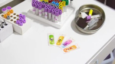 Mavi eldiven, laboratuarda durup test tüpünü tutabilmek için vakum tüpü yerleştirdi. Mikro küp. Vakum kan toplama tüpü.