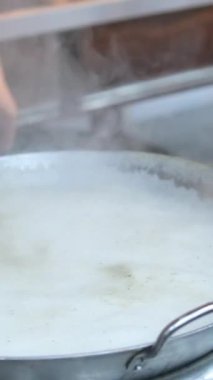 Bir restoranda deniz ürünleri pişirdikten sonra köpüklü kaynar su dökülür. Yüksek kalite 4k görüntü