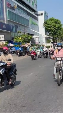 Ho Chi Minh Şehri motosikletleri maskeli ve miğferli insanlar taşıma araçlarıyla şehirde hızlı bir şekilde dolaşıyorlar. Yüksek kalite 4k görüntü