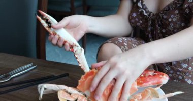 Bir restoranda yengeci özel bir aletle kesen kadın elleri. Büyük yengeç lezzetli pişirme. Masanın üzerinde kaynatılmış lüks bir otel büfesi. Yüksek kalite