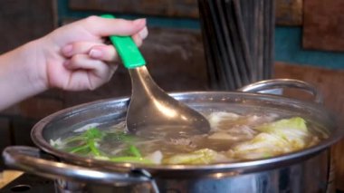 Yakın plan kızartma tavasında et suyu pilavı pilav vermicelli ve sebzeli kız Vietnam 'ı pişirmek için açık büfede yemeğini karıştırıyor. Vietnam çorbası pişir..