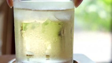 Yeşil buzlu çay. Bir fincan soğuk çayla nasıl karıştırılır. Yüksek kalite 4k görüntü