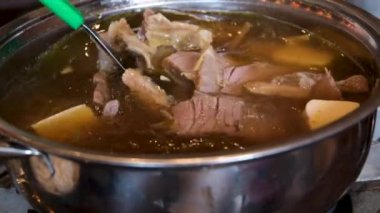 Yakın plan kızartma tavasında et suyu pilavı pilav vermicelli ve sebzeli kız Vietnam 'ı pişirmek için açık büfede yemeğini karıştırıyor. Vietnam çorbası pişir..