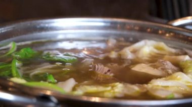 Yakın plan kızartma tavasında et suyu pilavı pilav vermicelli ve sebzeli kız Vietnam 'ı pişirmek için açık büfede yemeğini karıştırıyor. Vietnam çorbası pişir..