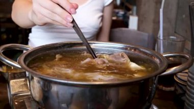 Yakın plan kızartma tavasında et suyu pilavı pilav vermicelli ve sebzeli kız Vietnam 'ı pişirmek için açık büfede yemeğini karıştırıyor. Vietnam çorbası pişir..