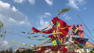  Uçurtmaların uçuşunun videosu ve Pinarella di Cervia plajında gökyüzünde pembe bir kelebek uçurtması. Uçurtma festivali. Vietnam Ho Chi Minh Şehri