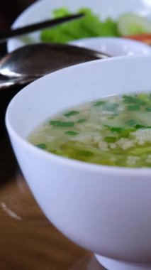 Vermeil ve tabakta bitkilerle birlikte tavuk çorbası yakın plan. Ayrıca tatlı ve ekşi soslu sebzeli pirinç.