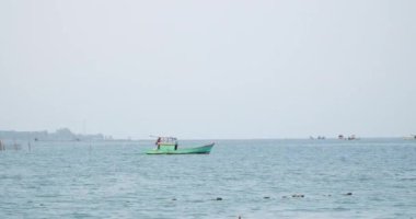 Balıkçılar, Vietnam 'daki Pu quoc adasında yelken açan küçük yeşil bir tekne. Yüksek kalite 4k görüntü