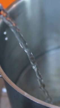 Ev idaresinde verimlilik, ev hanımının yakın çekim elleri kızartma tenceresi yıkama ve temizleme tenceresi, parlak mutfakta tencere, temizlik ve düzen sağlama. Elle yapılan çabalar.