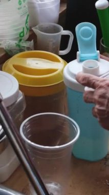Vietnam 'da yeşil portakallardan meyve suyu sıkan mükemmel bir kadın sokakta sağlıksız meyve sıkacağı. şeker şurubu ekle