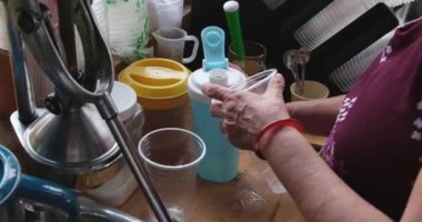 Vietnam 'da yeşil portakallardan meyve suyu sıkan mükemmel bir kadın sokakta sağlıksız meyve sıkacağı. şeker şurubu ekle