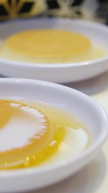 Lüks restoranda ya da kafede Fransız çiçeğiyle süslenmiş beyaz tabakta mangolu Panacotta tatlısı. Panna cotta tatlı krema, jöleli krema tropikal meyveli panacotta. jöleli puding