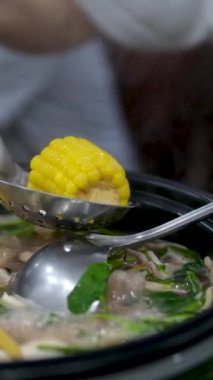 Geleneksel Dominik Creole yemekleri, Sancocho Corn çorbası kasede ve masada mısır. Geleneksel Meksika yemekleri yemek, Tex Mex mutfağı. Eller pişmiş quesadilla alıyor. 