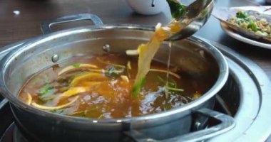 Makarna ve patates çorbası ile karıştırılmış kepçe tavuğu pencerenin yanındaki gaz sobasında küçük bir tencere içinde. Sebzeli çorba.
