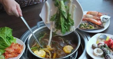 Baharatlı Çin güvecinin görüntüsü. Etkili bir yemektir. Lokantalar masanın ortasında kaynayan bir çorba tenceresinin etrafında malzemelerle birlikte otururlar. Sıcak tencere